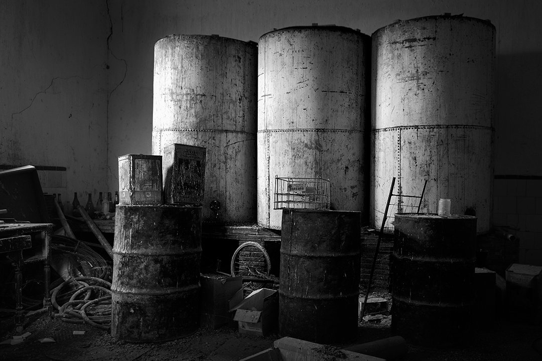Large cylindrical tanks in an abandoned interior.